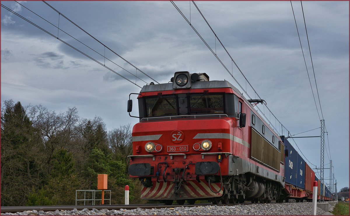 SŽ 363-010 zieht Containerzug an Črešnjevec vorbei Richtung Koper Hafen. /4.4.2018