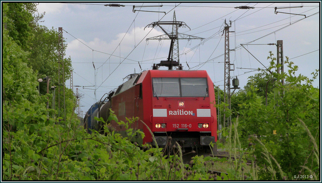 Sattes Rot umrahmt von frischen Grüntönen,der etwas andere Blick auf den herannahenden Güterzug bei Lintorf (Ratingen) im Mai 2013.Nennen wir es mal die Dackelperspektive.!