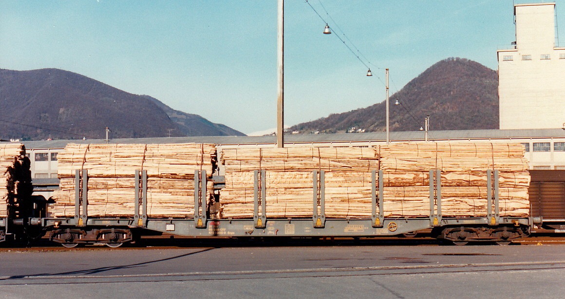 SBB-CFF Rungenwagen Snps mit Ladung Holzschwarten im SBB Gbf Chiasso, Dez. 1996