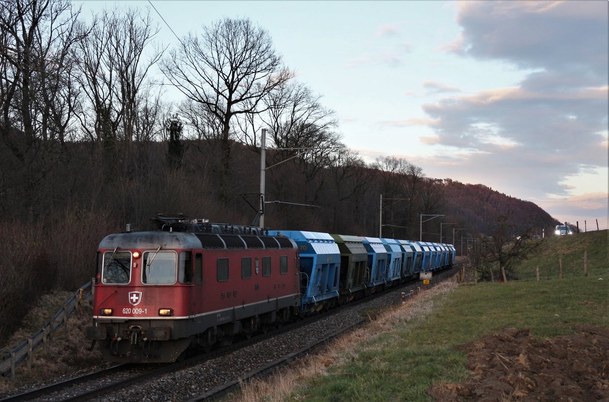 SBB Re 620 009-1  Uzwil  unterwegs mit einem Kiesgüterzug kurz nach dem Sonnenuntergang zwischen Embrach-Rorbas und Pfungen.

Aufgenommen am 16. März 2018