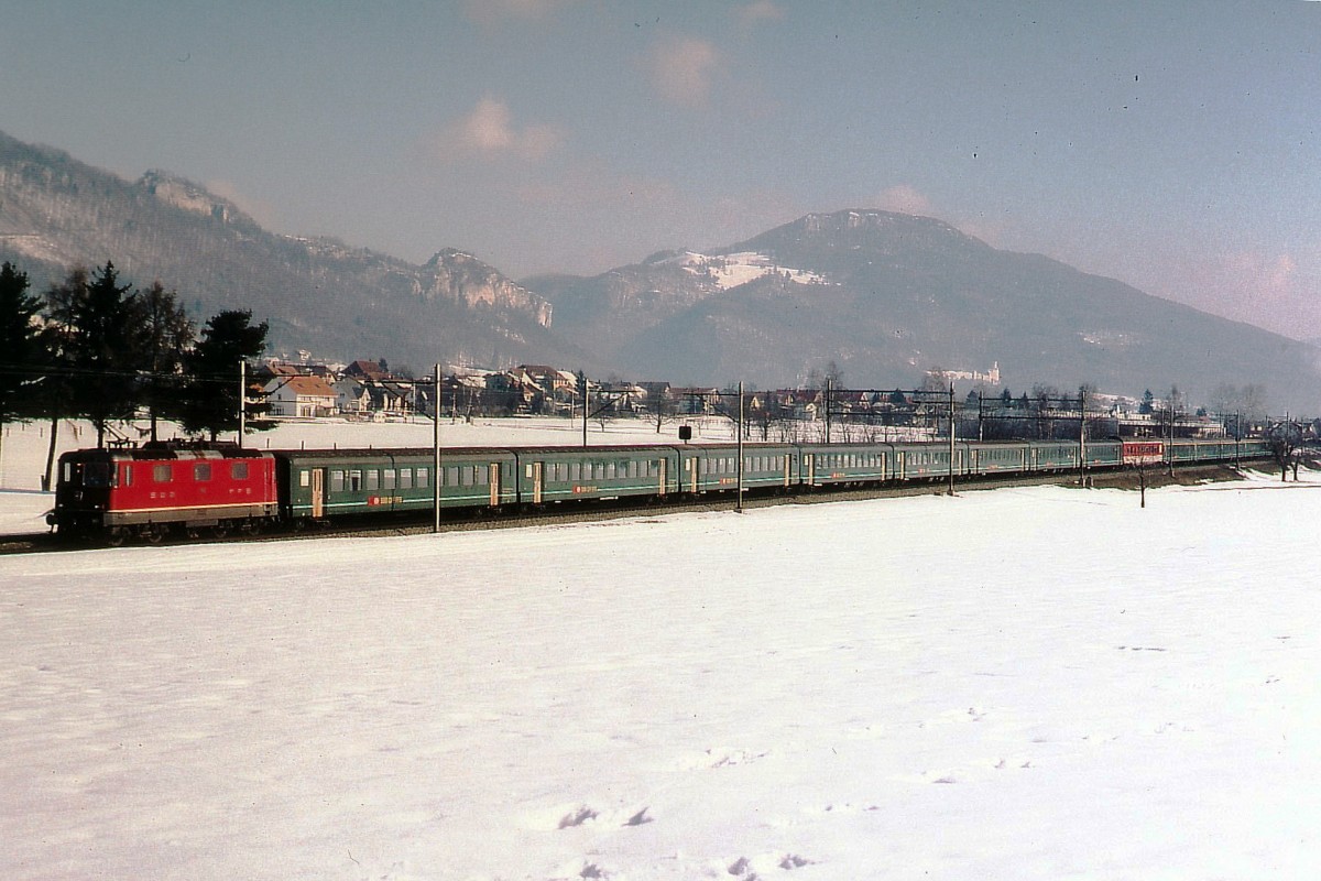 SBB: Vor der Inbetriebnahme der 44 Inter City-Neigezüge (ICN) RABDe 500 ab dem Jahre 1999, prägten die  dunkelgrünen Züge  das alltägliche Bild der Jurasüdfuss Linie. Zug mit Re 4/4 II und 13 EW II bei Niederbipp im Winter 1998.
Foto: Walter Ruetsch
 
