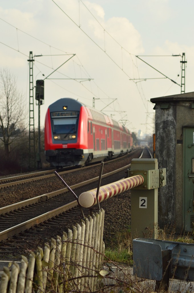 Schrankenbaum an einem Feldwegübergang bei Kaarst.
Im Hintergrund kommt ein RE7 nach Krefeld Hbf heran gefahren.
Sonntag 22.2.2015