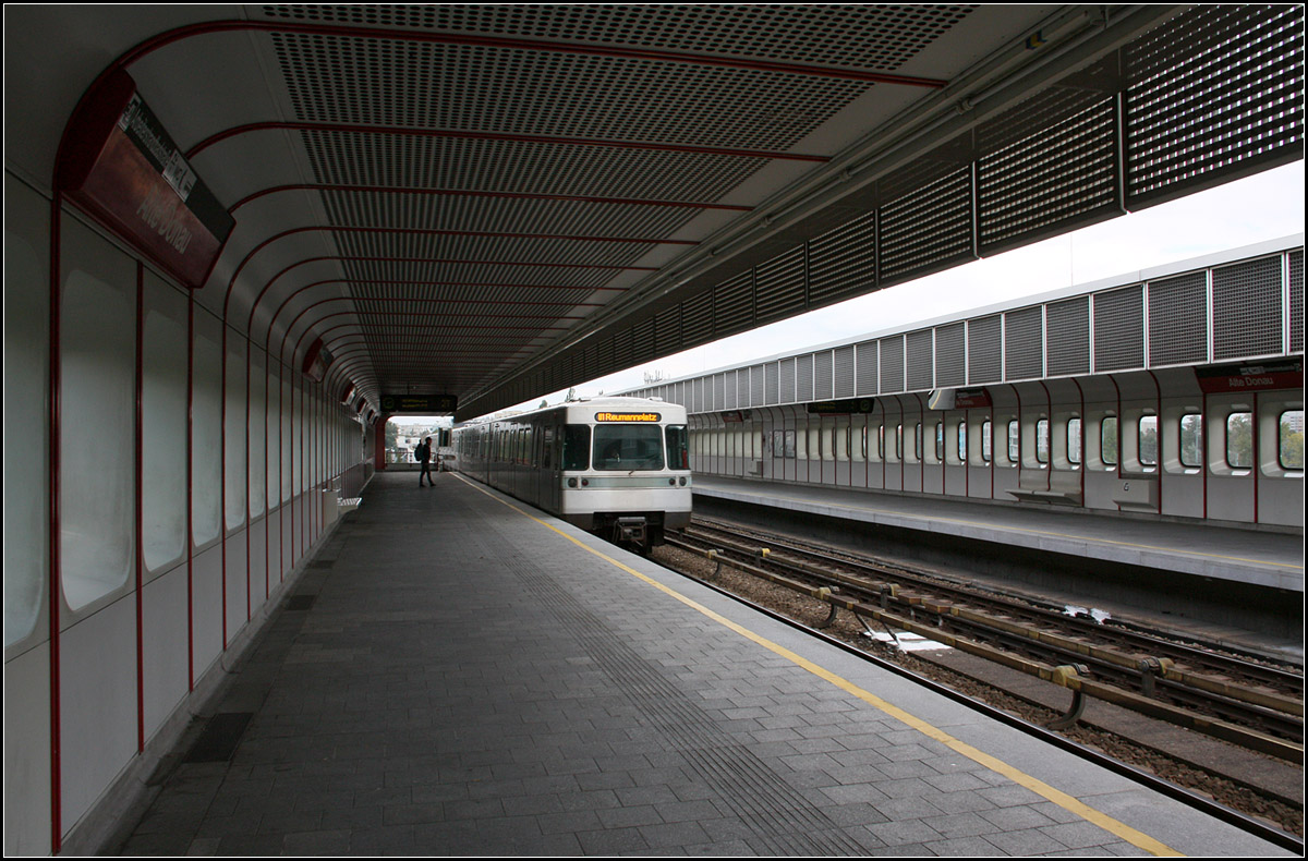 Seinerzeit hochmodern -

Die meisten Stationen der ersten Ausbaustufe der Wiener U-Bahn entlang der Linie U1 und U4 wurden durch die Architektengruppe U-Bahn einheitlich gestaltet. Auffällig sind die Abrundungen zwischen Wand- und Decken und die in der jeweiligen Linienkennfarbe ausgeführte Abdeckungen zwischen den Wand- und Deckenverkleidungs-Elemente. Die früheren Zugzielanzeigen waren auch in diese Design-System integriert. Obwohl schon viel Zeitgeist der siebziger Jahre in den Formen stecken, kann man es heute durchaus noch sehen. Hier der Hochbahnhof Alte Donau der U1.

Die selben Architekten waren auch an der Gestaltung von Stationen in Bonn und Vancouver (Kanada) beteiligt.

08.10.2016 (M)
