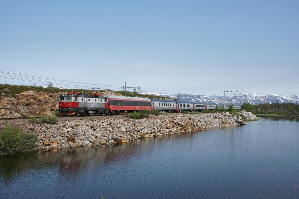 Sommerferien in Skandinavien, 2. Teil: An der Malmbahn: Nicht gerade dicht ist der Personenverkehr auf der Erzbahn Kiruna-Narvik. Es verkehren in jede Richtung genau zwei Züge. Einer dieser Züge ist der Nachtzug Stockholm-Narvik, welcher am 12.07.2015 von der Rc 6 1328 gezogen wird. Das Bild wurde bei Vassijaure aufgenommen.