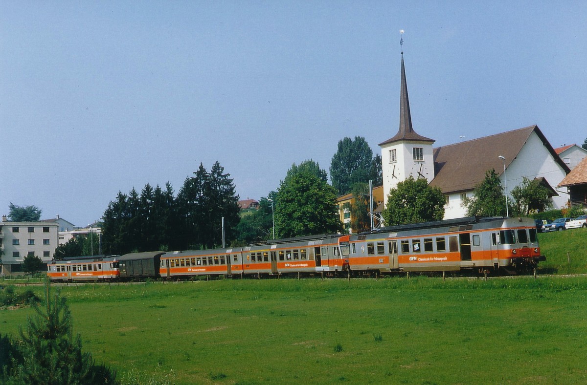 TPF/GFM: Regionalzug Murten-Fribourg ausnahmsweise mit RBDe 4/4 172, RBDe 537 181 und RBDe 4/4 173 bei Courtepin im Juli 1991. Damals wurde noch Montag bis Freitag planmässig bei einzelnen Zügen ein Postwagen mitgeführt.
Foto: Walter Ruetsch  