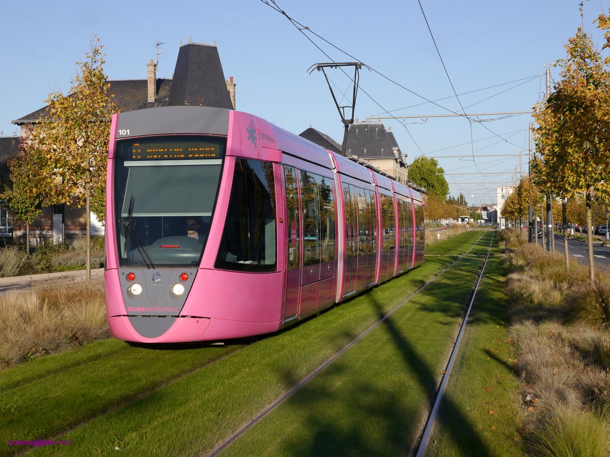 Tram CITURA-101 (Citadis-302 Alstom2010) unterwegs auf Rasengleis als Ligne-B  Richtung Hôpital-Debré. Die im Farbton Fuchsia lackierte Bahn ist die erste neue Straßenbahn des neuentstandenen und 2011 in Betrieb genommen Tramsystems von Reims.
2014-10-18 Reims Boulevard-des-Belges