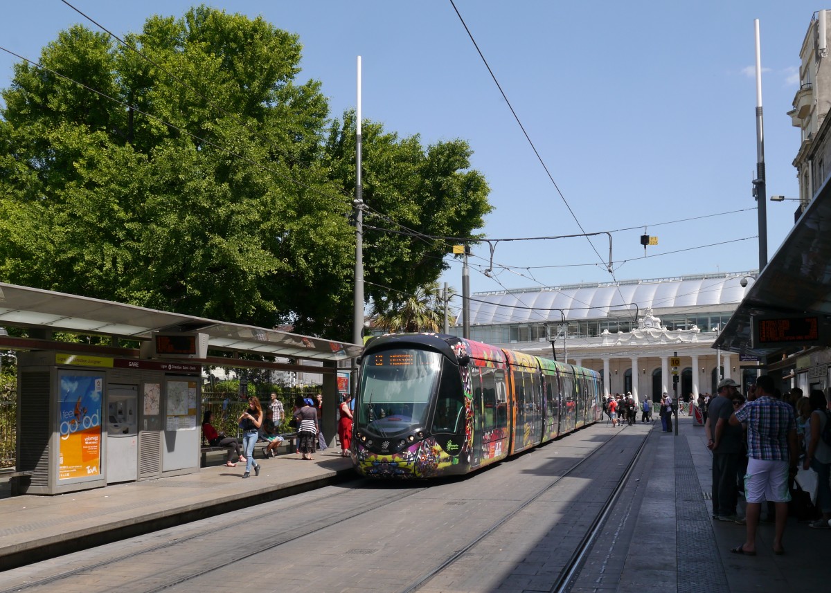 Tram TaM-2072 (Citadis402 Alstom) unterwegs auf der Ligne 3 nach Juvignac.
 
Die TaM (Transports de Montpellier Méditerranée Métropole)hat für jede der 4 existierenden Linien gesondert gestaltete Fahrzeuge im Einsatz. 

2015-05-30  Montpellier Gare-Saint-Roch 