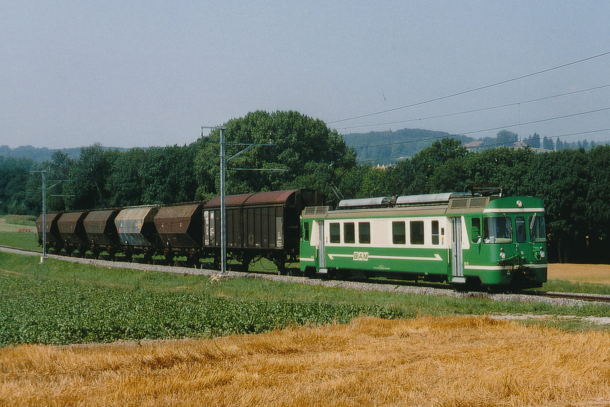 Transports de la région Morges-Bière-Cossonay, MBC/BAM.
Im Jahre 1993 wurde bei der BAM noch der gesamte Güterverkehr mit den Be 4/4 11, 12, 14 und 15 bewältigt. Auf die Belegung der Betiebsnummer 13 wurde absichtlich verzichtet. Für die Führung der Personenzüge standen die BDe 4/4 aus dem Jahre 1943 im Einsatz. Dabei dienten die damals neuen Steuerwagen als Beiwagen.
Getreidezug mit dem Be 4/4 11 bei Bussy-Chardonney auf der Fahrt nach Morges im August 1993.
Foto: Walter Ruetsch  