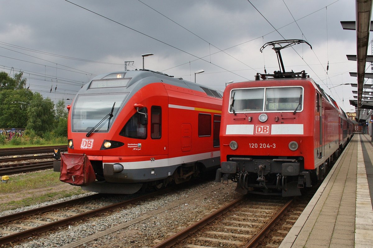 Treffen von 429 530-9 als RE9 (RE13011) Rostock Hauptbahnhof-Sassnitz und 120 204-3 mit einem RE1 (RE4309)  Hanse-Express  Hamburg Hauptbahnhof-Rostock Hauptbahnhof am 3.9.2016 in Rostock. 