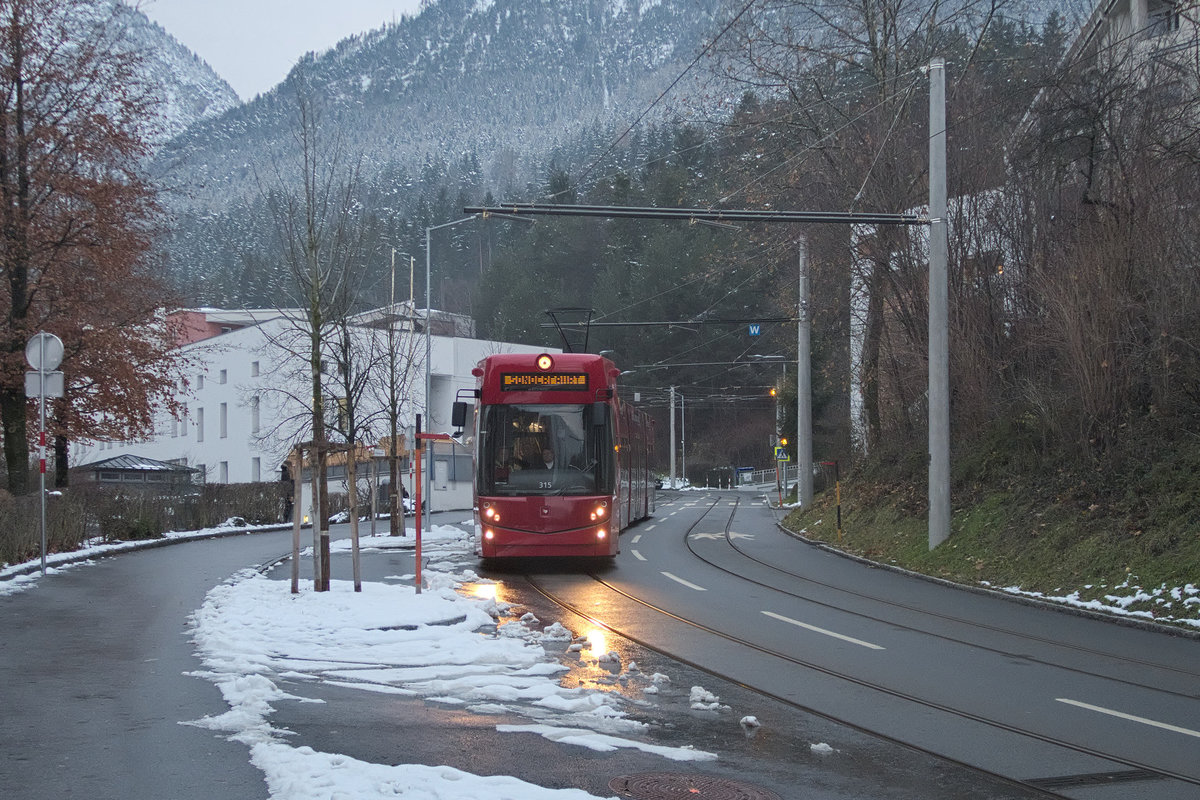 TW 315 (Bombardier Flexity Outlook C) nimmt vorsichtig das max. Gefälle von 8,5 % von der Peerhofsiedlung herab als Publikumsfahrt zur Einweihung der Straßenbahnerweiterung in Innsbruck Richtung Westen. Aufgenommen 5.12.2017.