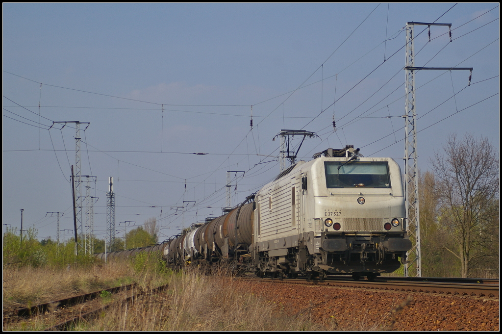 TWE E 37527 mit Zacens in Berlin Wuhlheide, 24.04.2015
<br><br>
Die Prima EL3U ist bei der Teutoburger Wald-Eisenbahn AG im Einsatz und kommt mit einem Kesselwagen-Zug durchgefahren. Standort ist an einem öffentlich zugänglichen Punkt am alten Bü (NVR-Nummer 91 87 0037 527-5 F-CBR)