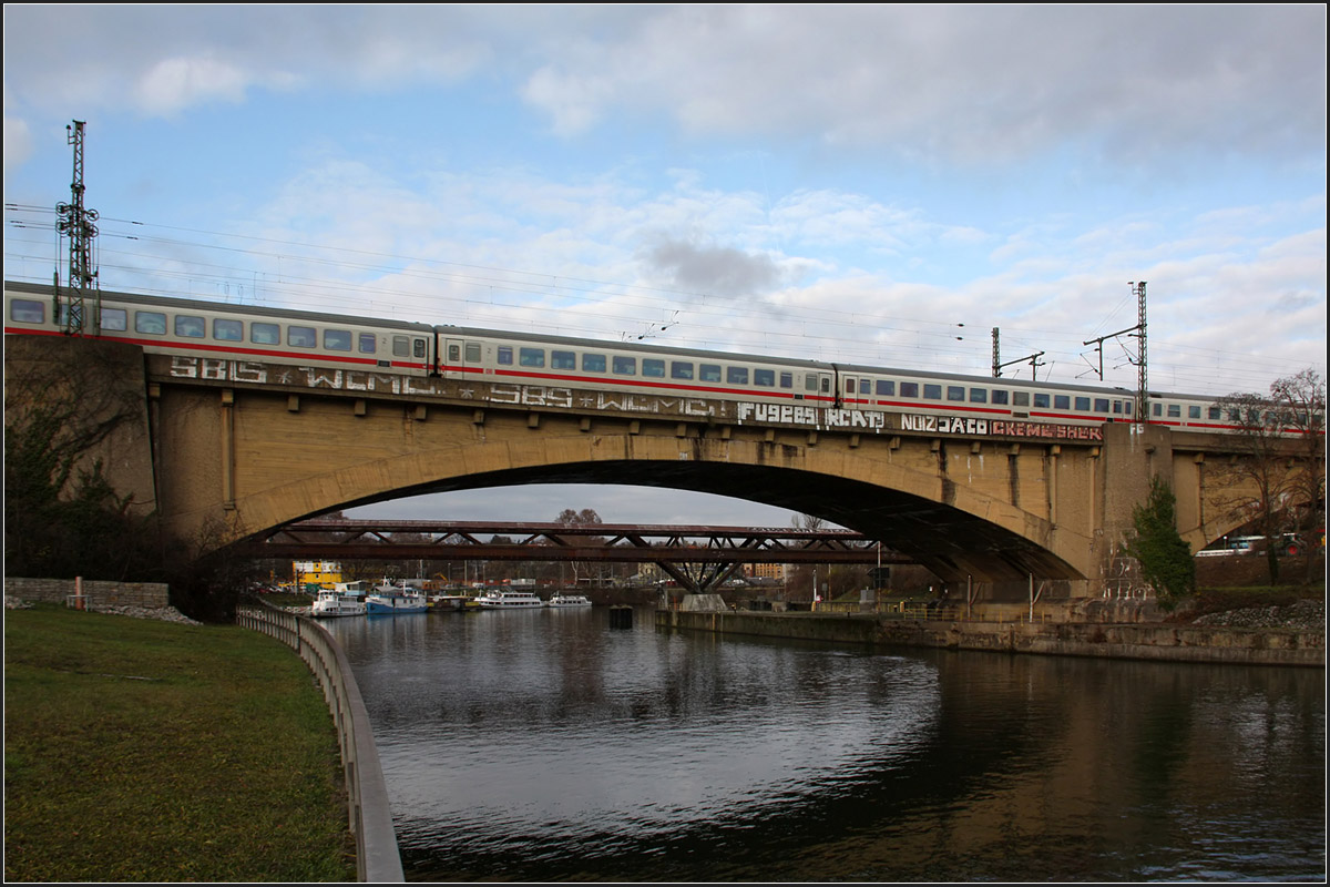 Über den Neckar -

Die viergleisige Rosensteinbrücke ging 1915 in Betrieb. Sie entstand damals im Zusammenhang mit dem Neubau des Stuttgarter Hauptbahnhofes. Damals wurde die Strecke Bad Cannstatt - Stuttgart Hbf viergleisig neu gebaut. Die zuvor bestehende zweigleisige Bahnbrücke lag etwa zwischen dieser Brücke und der geplanten neuen Brücke, die für Stuttgart 21 entstehen wird.

17.12.2015 (M)

