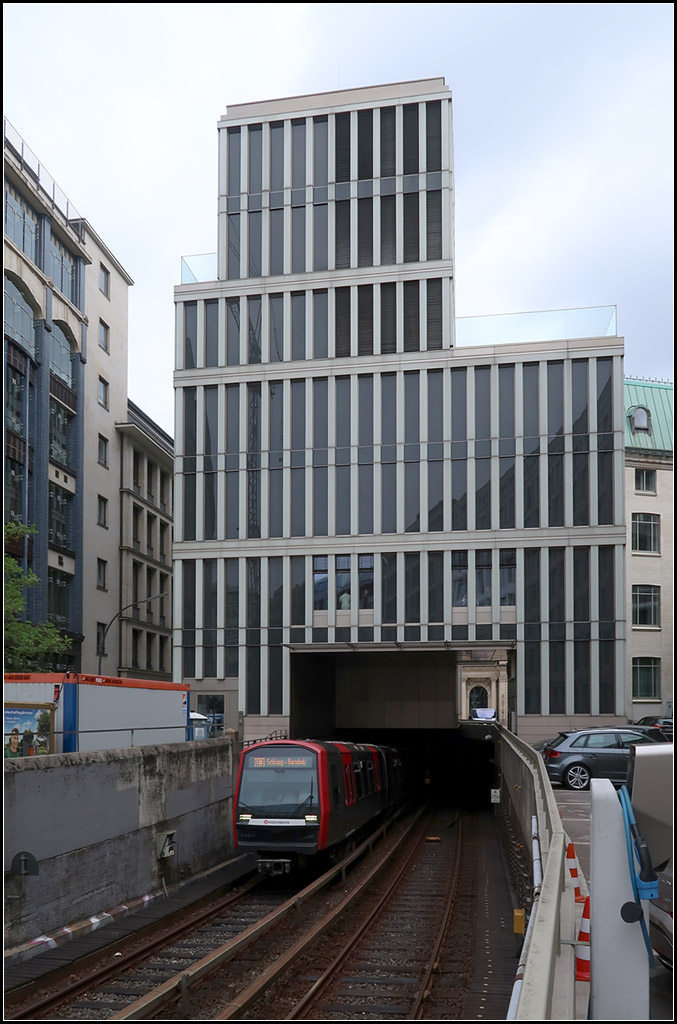 Unter dem Neubau hervor -

Die U-Bahnrampe zwischen den Station Rathaus und Rödingsmarkt wurde im Bereich des Tunnelportals mit einem Gebäude überbaut. Blick auf einen die dortige Steigung erklimmenden U-Bahnzug auf der Hamburger Linie U3.

15.08.2018 (M)