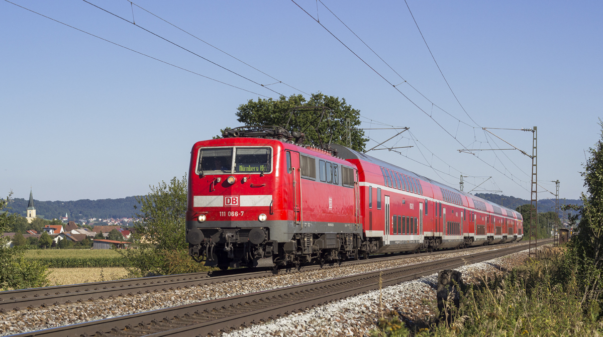 Unter strahlend blauem Himmel eilt 111 066-7 mit ihrem RE nach Nrnberg durch die Oberpfalz, hier bei Plling (06.09.2013)