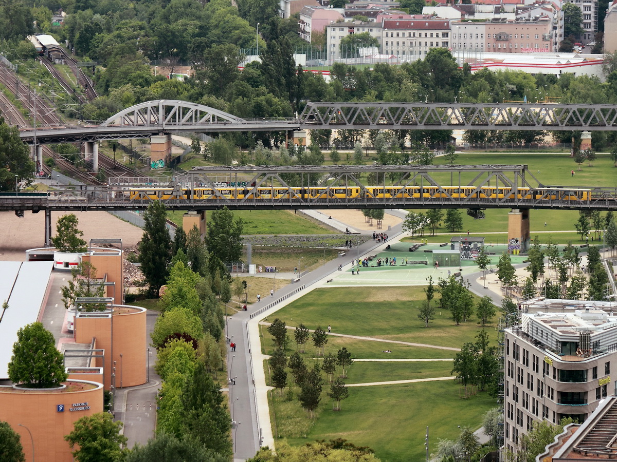 Unweit des Parkhaus Gleisdreieck passiert hier eine unbekannte U-Bahn die Brücke über den Park in dem man  entspannt flanieren kann.  Gesehen am 3. Juni 2015 vom Panoramapunkt auf dem Potsdamer Platz. 