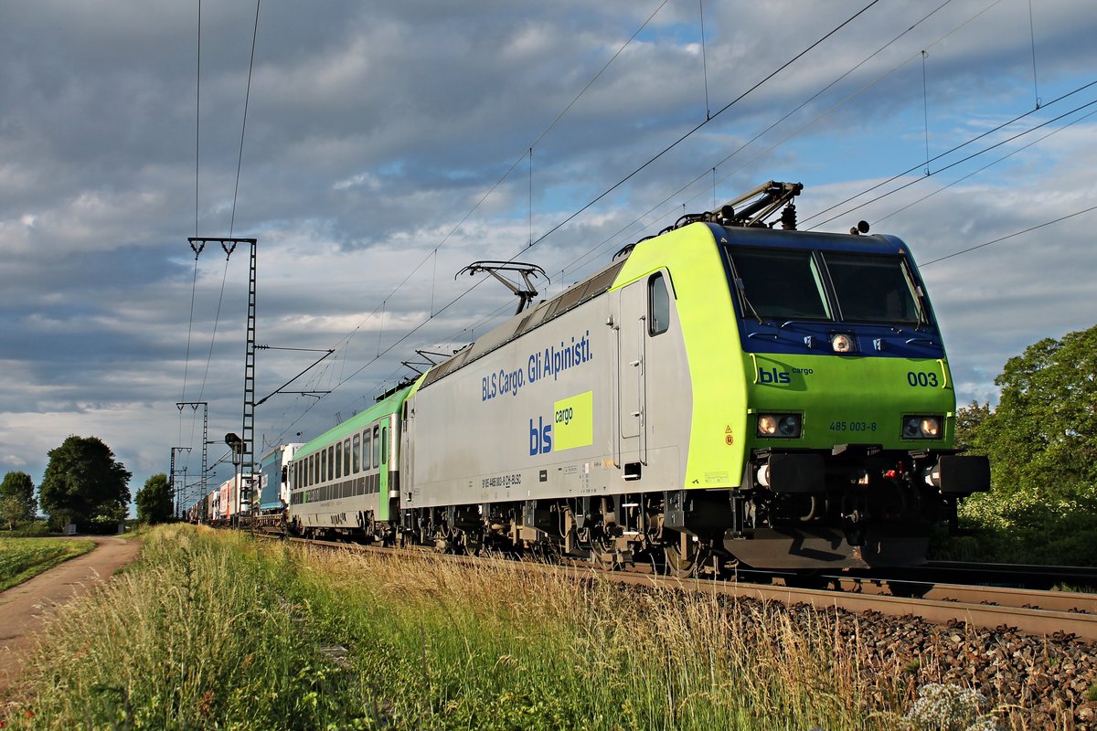 Von der Abendsonne angeleuchtet fuhr am 06.06.2017 die Re 485 003-8  BLS Cargo. Gli Alpinisti  mit einer RoLa (Freiburg (Brsg) Rbf - Novara Boschetto), die sie bis Domodossola bespannen wird, bei Müllheim (baden) in Richtung Basel. Interessant ist auch, dass bei der Werbung von der Re 485 003-8 der Kopf auf beiden Seiten entfernt worden sind.