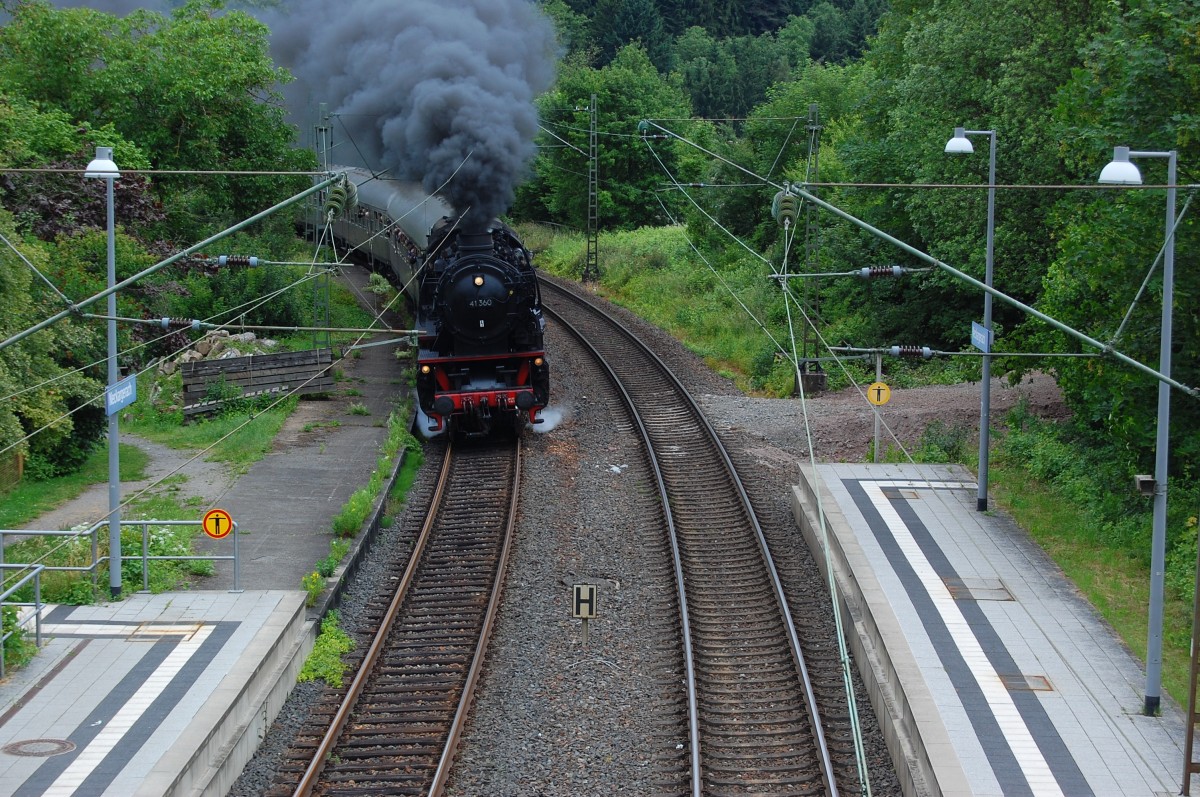 Von der Fußgängerbrücke in Neckargerach erwischte ich ehr zufällig am Freitag den 30.5.2014 die 41 360 mit einem  Postzug  aus Neustadt a.d. Weinstraße kommend auf ihrem Weg nach Heilbronn in Museum. Hier hat sie gerade die Straßenbrücke überquert.