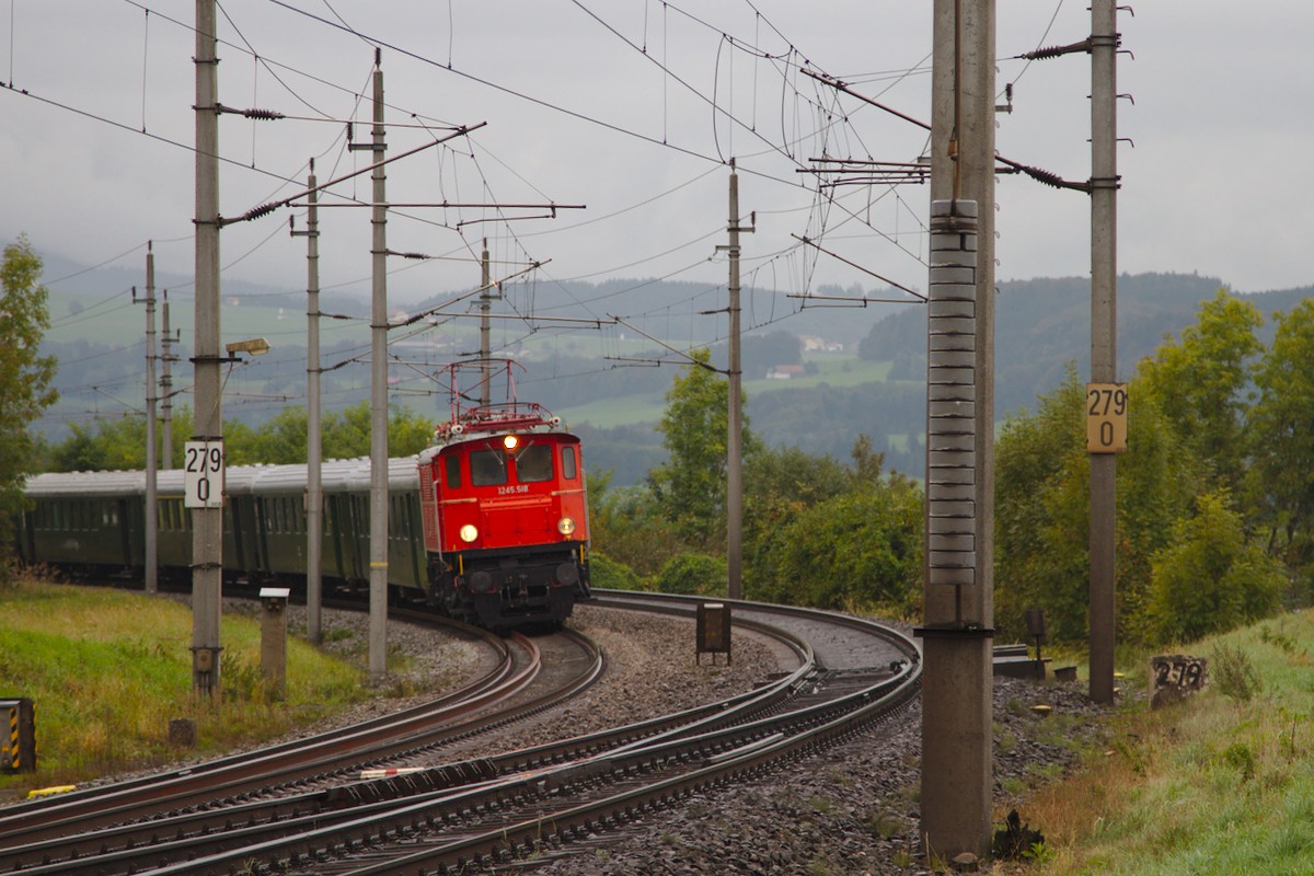 Von Steindorf bei Straßwalchen bis Timelkam wurde der Sonderzug mit dem tschechischen 486.007 von der 1245.518 gezogen, während die Dampflok hier im Bild nicht zu sehen, am Zugende mitlief. Zu sehen ist der Zug in der Einfahrt Ederbauer. (02.2016)