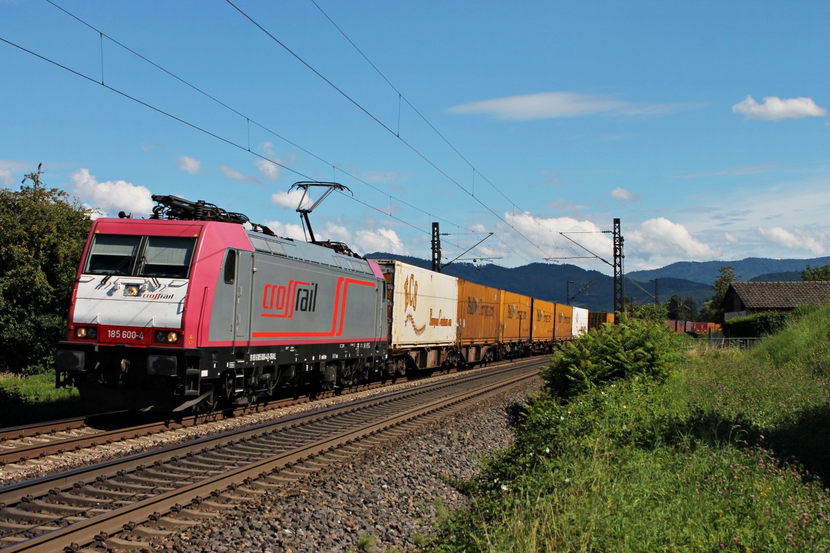 Vorbeifahrt am 08.08.2014 von der sehr sauberen Crossrail 185 600-4 mit einem Containerzug in Richtung Aachen West bei Kollmarsreute vor dem Schwarzwald.
