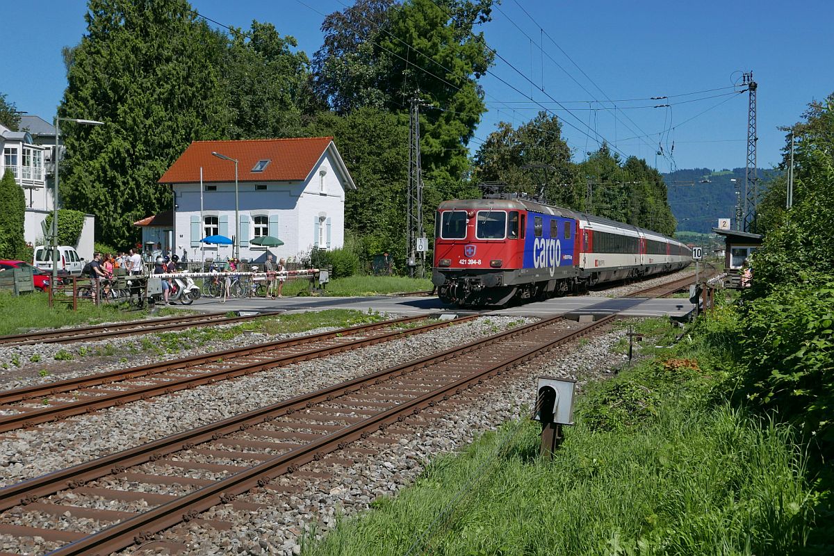 Vorher# Lindau, Langenweg, mit Bahnbergang. Am 13.08.2016 passiert Re 421 394-8 mit den Wagen des EC 195, Zrich - Mnchen, den Bahnbergang Langenweg in Lindau.