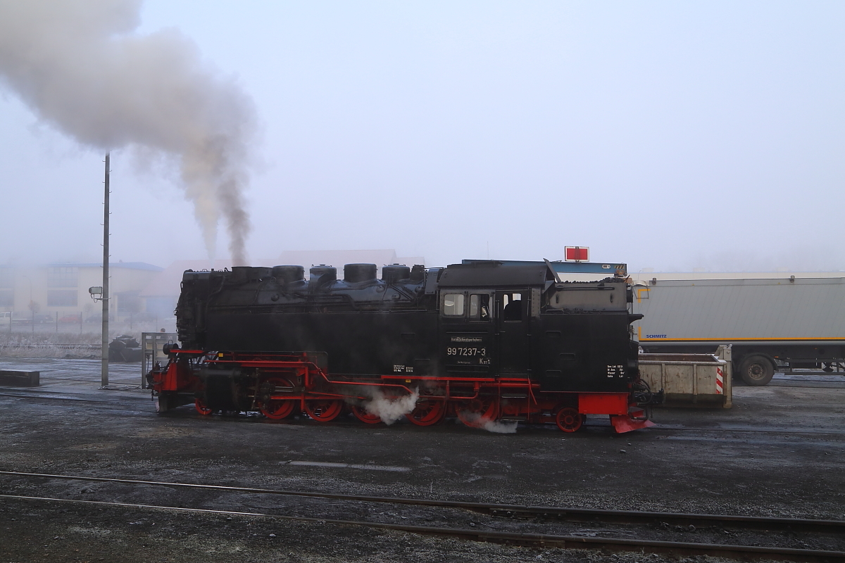 Während 99 7237 am 13.02.2015 im Bw Wernigerode auf ihre Bekohlung wartet, liefert im Hintergrund ein Sattelschlepper bereits Nachschub für die Bekohlungsanlage an.