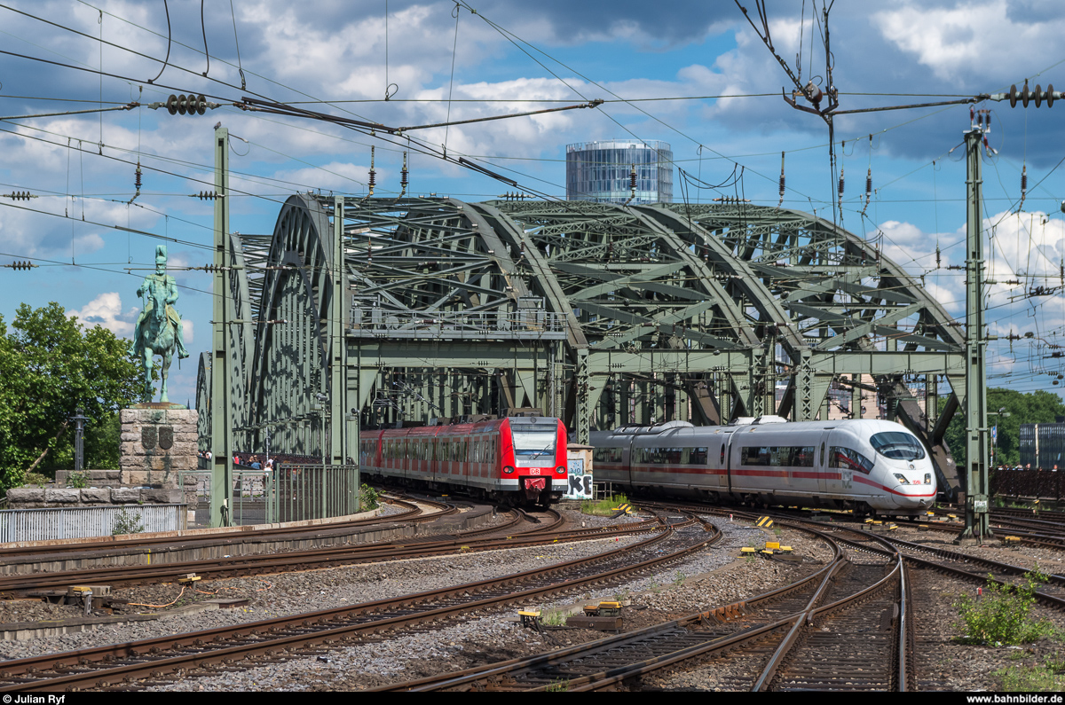 Während ein 423 gerade auf die Hohenzollernbrücke auffährt, ist ein ICE 3 in Gegenrichtung unterwegs und wird in wenigen Augenblicken in Köln Hbf anhalten.