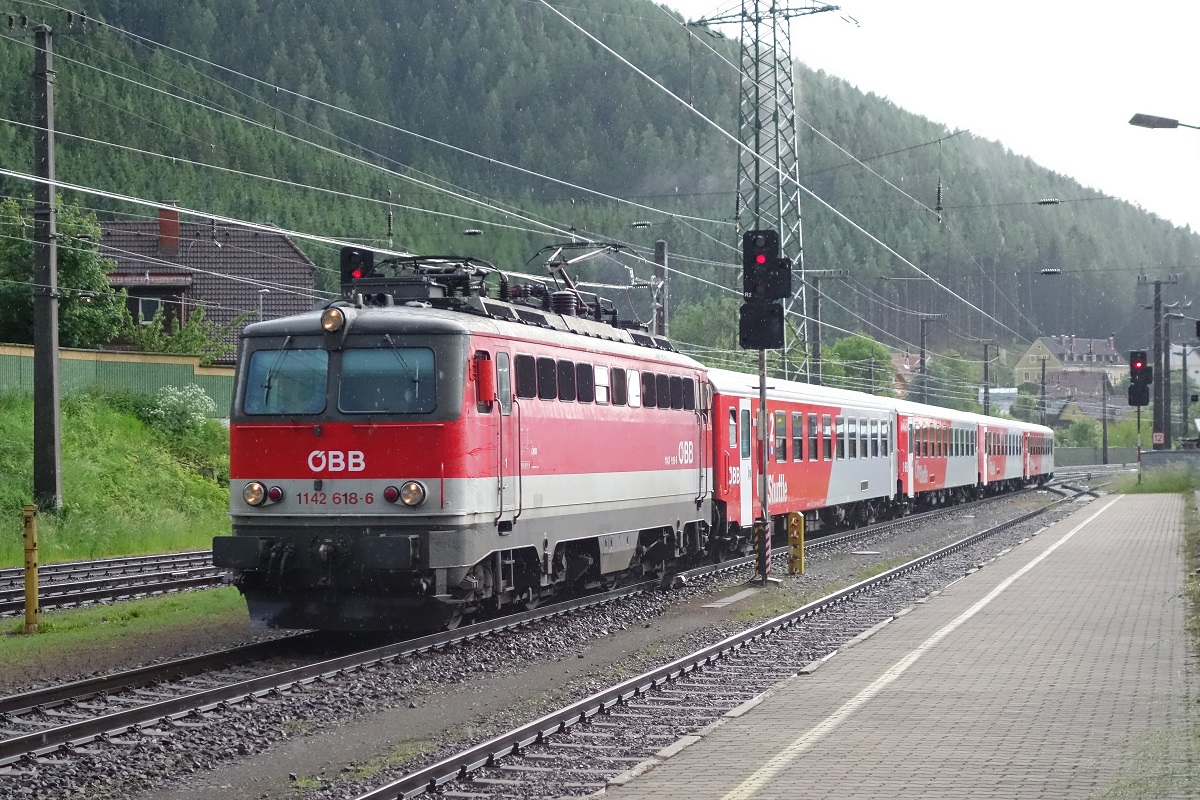 Während eines Gewitterregen fährt 1142.618 mit einem Regionalzug in den Bahnhof Kindberg ein. Das Bild stammt vom 30.05.2016.