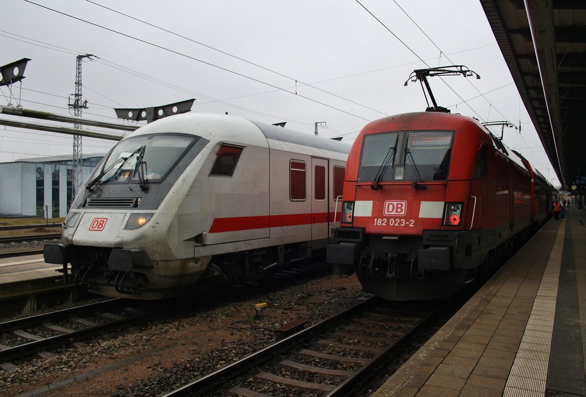 Während der IC2417 geschoben von 101 015-6 nach Köln Hauptbahnhof den Rostocker Hauptbahnhof verlässt, steht 182 023-2 mit dem RE1 (RE4310)  Hanse-Express  nach Hamburg Hauptbahnhof bereit. (5.2.2017)