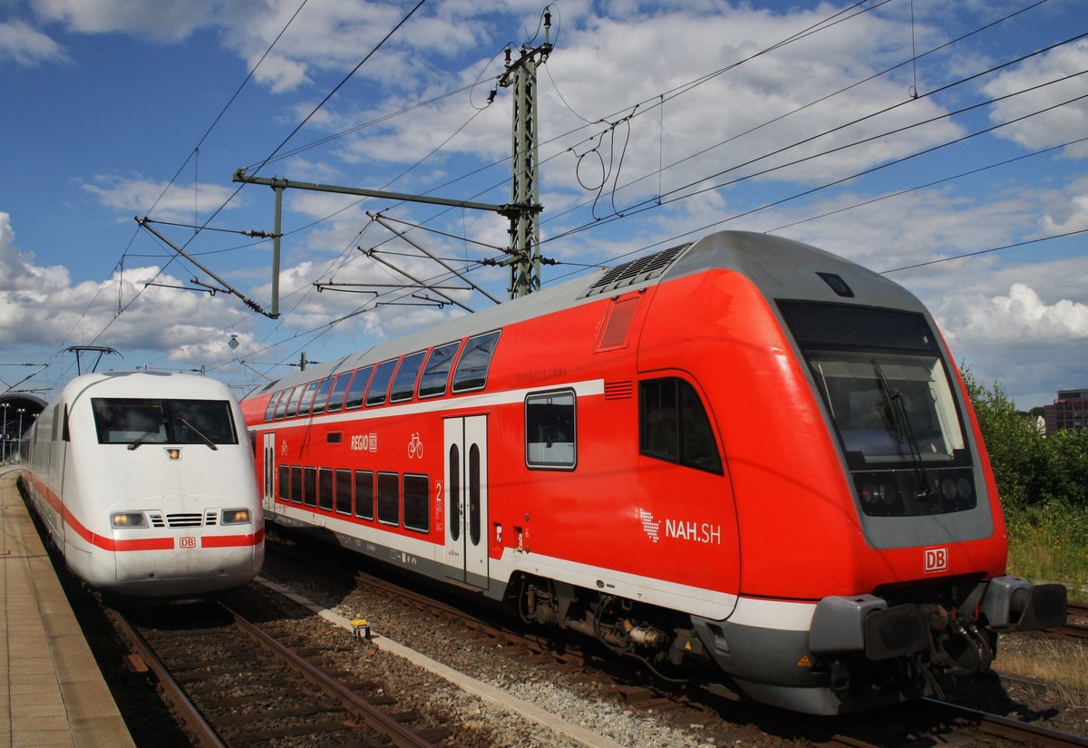 Während der RE83 (RE21629) nach Lübeck Hauptbahnhof von 218 329-1 bereitgestellt wird, wartet 401 585-5  Freilassing  als ICE273 nach Karlsruhe Hauptbahnhof in Kiel auf Ausfahrt. (28.6.2016)