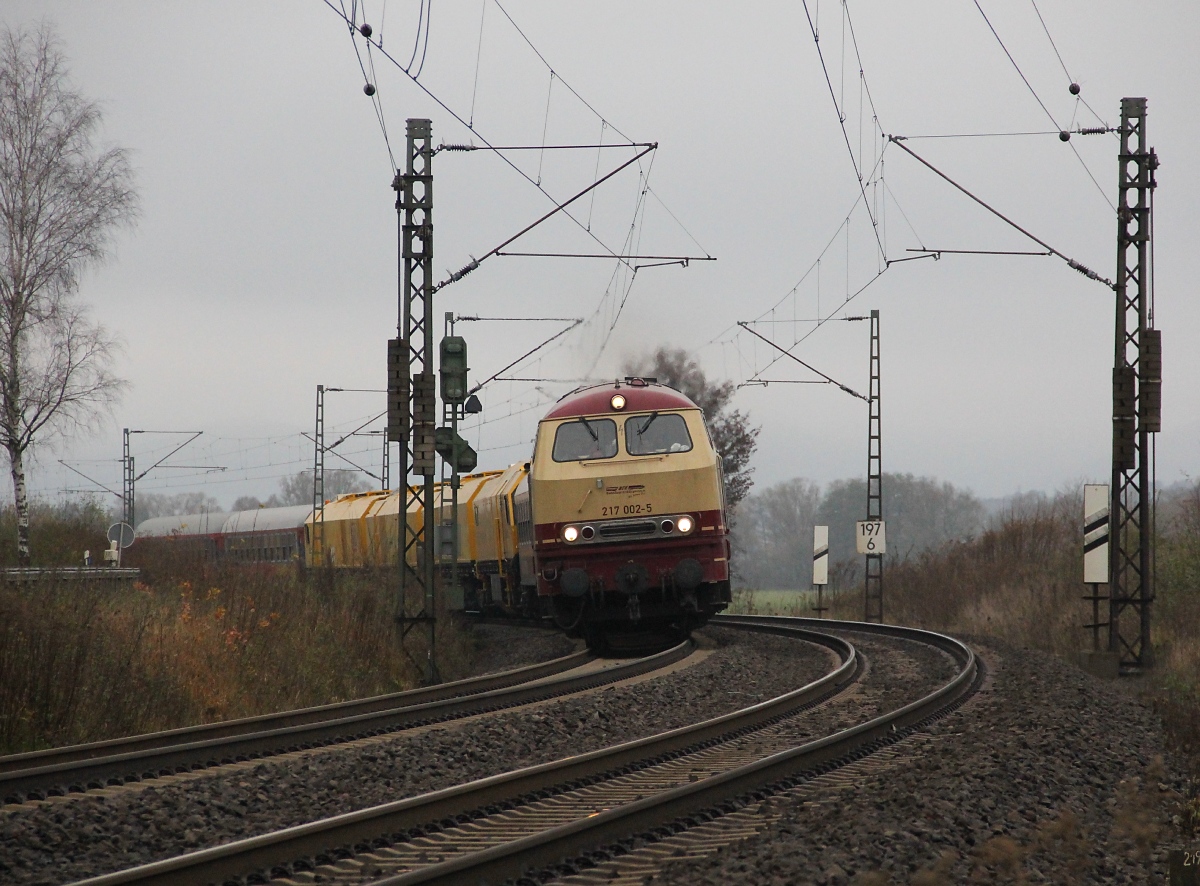 Was kommt denn da um's Eck!? Es ist 217 002-5 mit einer neuen Schienenschleif-Maschine im Gepäck. Aufgenommen am 22.11.2013 bei Wehretal-Reichensachsen.