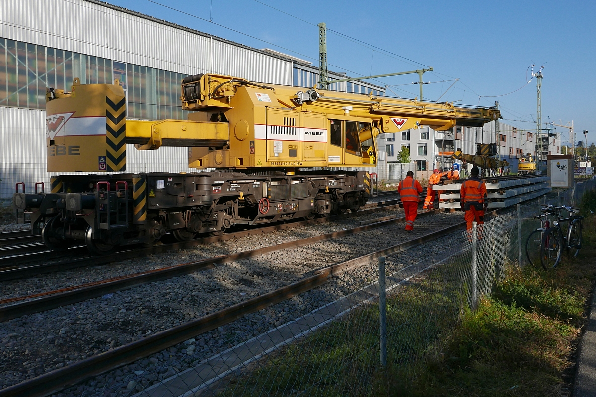 Weichenerneuerung in Konstanz-Petershausen - Gleisbauschienenkran (KRC 810 T, 99 80 9419 013-4 D-HFW) nimmt ein Zwischenstck auf, das die Lcke zwischen neuer Weiche und bestehendem, alten Gleis schlieen wird (15.10.2016).