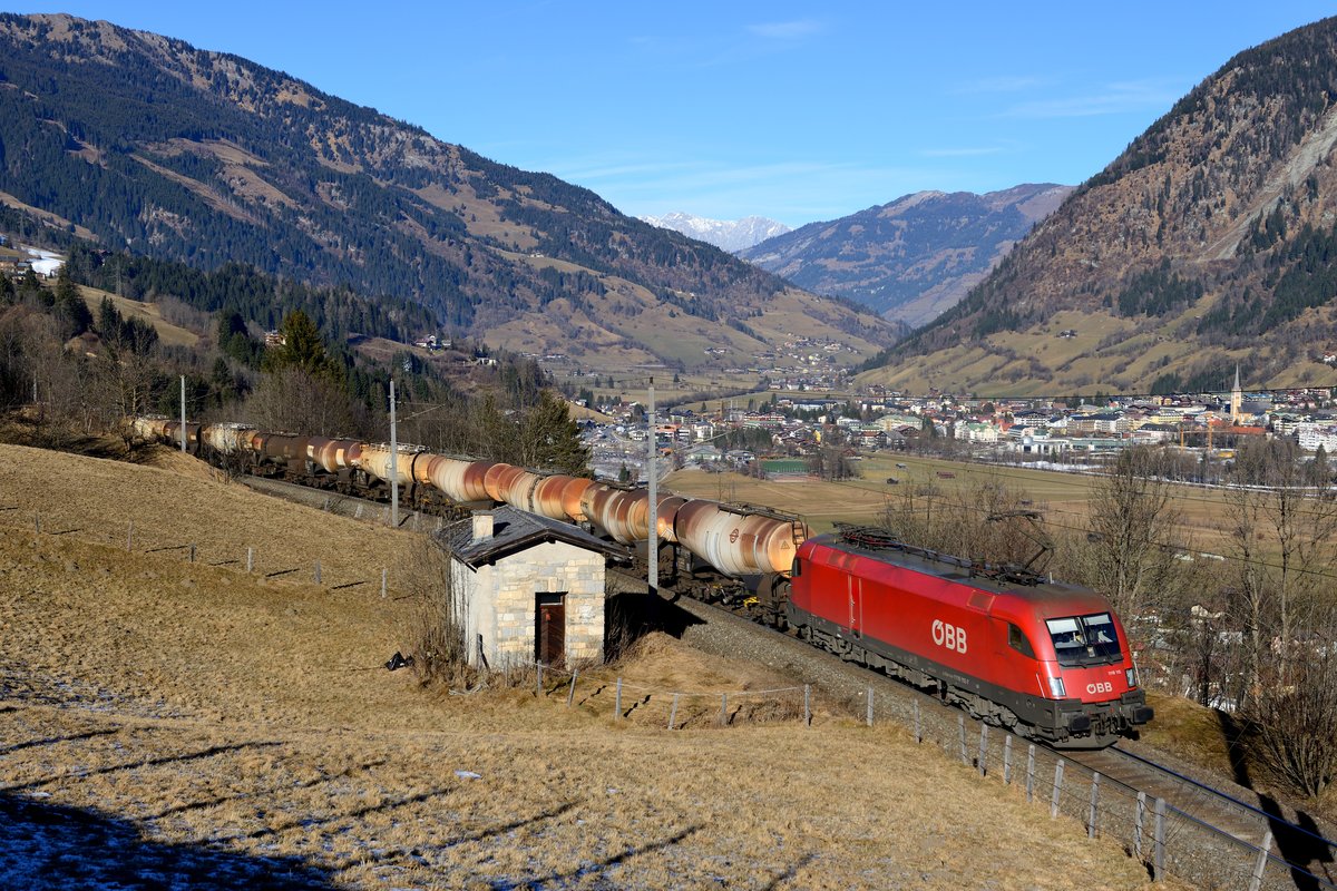 Wenigstens ein Güterzug ging sich am 22. Dezember 2016 aus: Zur Mittagszeit passierte die 1116.115 mit dem leeren Kreideschlamm-Zug G 49905 nach Gummern die bekannte Fotostelle bei Anger mit dem herrlichen Blick über Bad Hofgastein und das noch schneelose Gasteinertal.