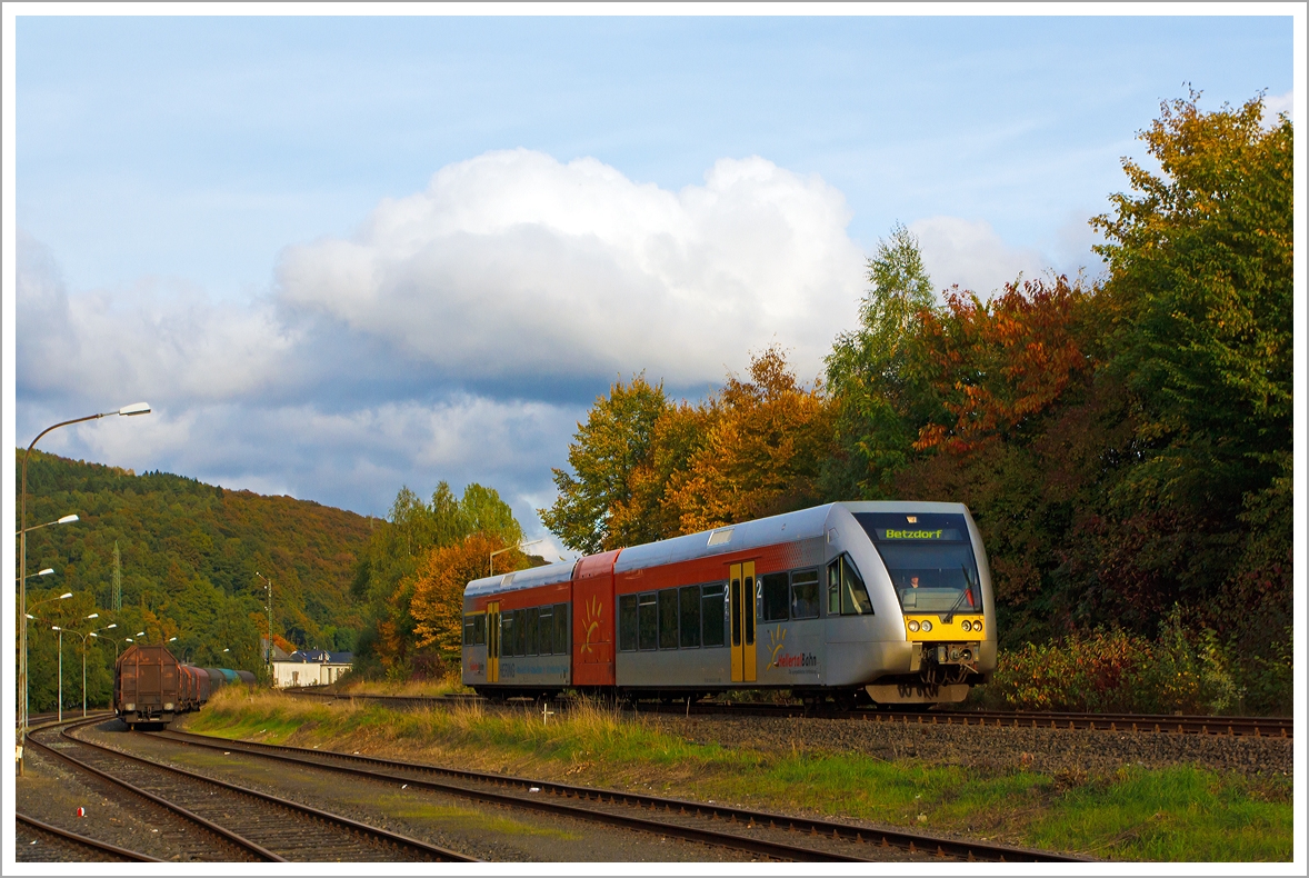 Wenn die Sonne mal durchkommt, so  gibt es ein kleinwenig goldenen Oktober...

Der Stadler GTW 2/6 VT 118 der Hellertalbahn als RB 96 Betzdorf-Herdorf-Neunkirchen, hier am 13.10.2013 kurz vor dem Bahnhof Herdorf.

Er fhrt als RB 96 (Hellertalbahn) die Verbindung Dillenburg-Haiger-Burbach-Neunkirchen-Herdorf-Betzdorf/Sieg (Umlauf HTB90426), ber die gleichnamentliche Strecke Hellertalbahn (KBS 462).

Im Vordergrund der Rangierbahnhof der KSW Kreisbahn Siegen-Wittgenstein (ehem. Freien Grunder Eisenbahn AG), hier ist Sonntagsruhe, es sind nur einige Wagen fr Coiltransporte der Gattung Shimmns abgestellt.