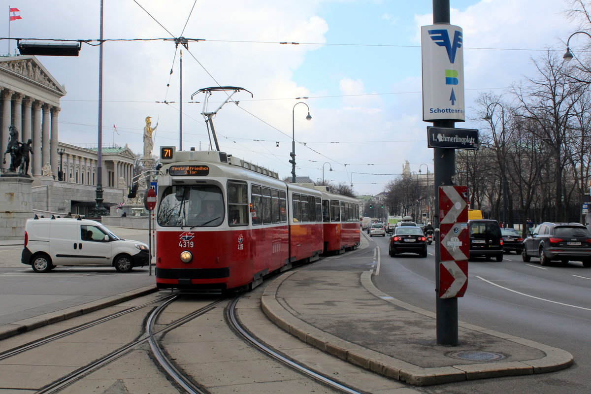 Wien Wiener Linien SL 71 (E1 4319) Innere Stadt, Dr.-Karl-Renner-Ring / Schmerlingplatz am 24. März 2016. - Links im Bild sieht man einen Teil des Parlaments. Der dänisch-österreichische Architekt Theophil Hansen (1813 in Kopenhagen geboren, 1891 in Wien gestorben) errichtete in den Jahren 1873 bis 1883 das ursprüngliche Reichsratsgebäude (ab November 1918 Parlament). Vor dem Parlamentsgebäude steht seit 1902 der Pallas-Athene-Brunnen. Sowohl der klassizistische Baustil des Parlaments als auch der Brunnen lenken die Gedanken auf die Wiege der Demokratie im antiken Athen. 