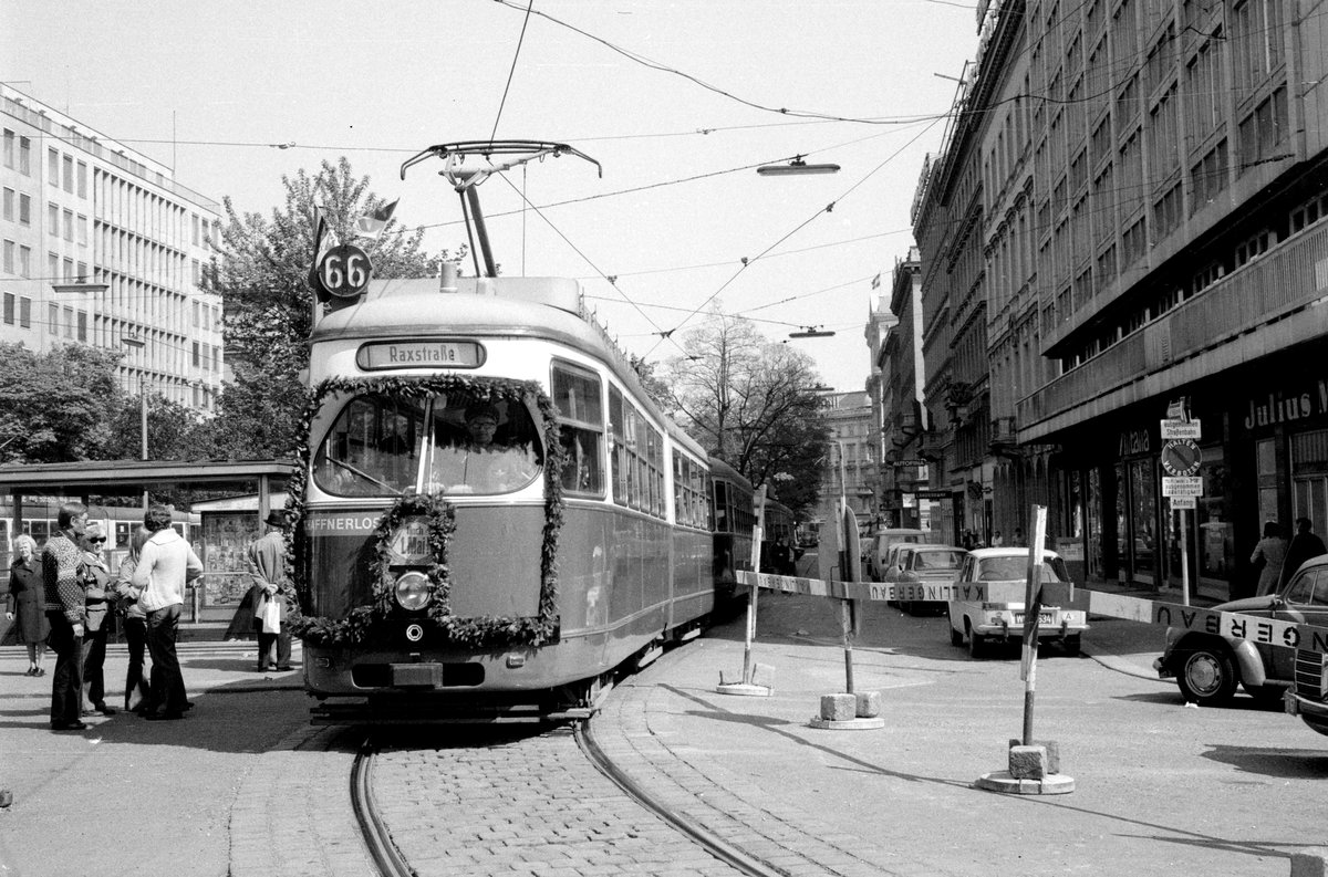 Wien WVB: SL 66 beim Verlassen der Endstation Ring / Oper (Kärntner Ring / Kärntner Straße) am 1. Mai 1976. - Bis 1998 begann am 1. Mai der Betrieb auf den Straßenbahnlinien erst ca. 14 Uhr. Der erste Zug jeder Linie fuhr dann geschmückt, so wie es auf dem Bild von der SL 66 zu sehen ist. - Scan von einem S/W-Negativ. Film: FP 4. Kamera: Kodak Retina Automatic II.