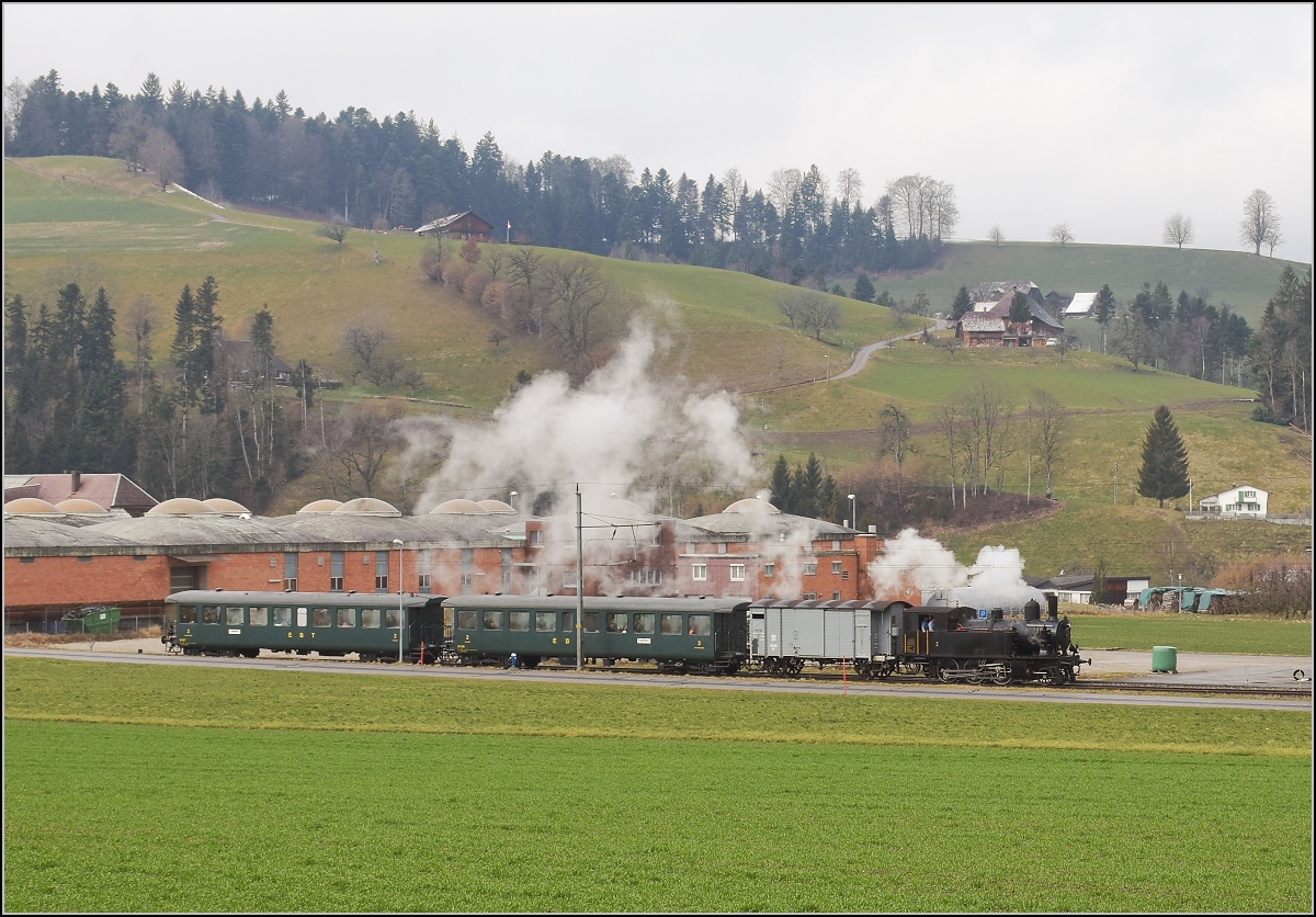 Winterdampf des Vereins Historische Emmentalbahn. Dampflok Ed 3/4 Nr. 2 der Solothurn-Münster-Bahn in Huttwil. Mit im Gepäck hat sie zwei vierachsige Leichtstahlplattformwagen und einen K2. Februar 2018.