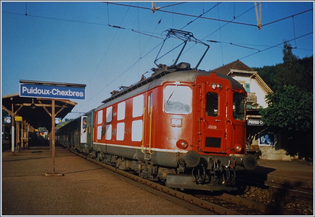 Wird auch heute noch gern und oft fotografiert: Die SBB Re 4/4 I 10019, heute bei der Centralbahn im Einsatz; damals als das Bild entstand, beim Halt mit einem Regionalzug von Payerne nach Lausanne in Puidoux Chexbres im Sommer 1993.
(Analoges Bild) 