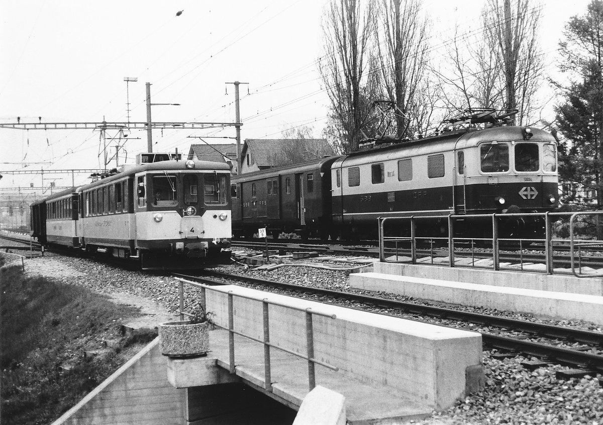 YSC/SBB: Zufällige Begegnung auf dem parallel verlaufenden Streckenabschnitt bei Yverdon les Bains zwischen dem YSC Be 4/4 4 und der SBB Re 4/4 I 10034 im April 1987.
Foto: Walter Ruetsch