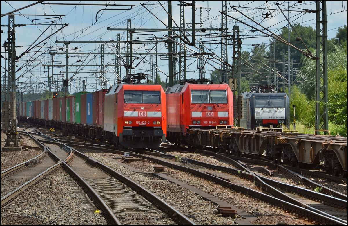 Zugbegegnung von 152 022-0 und 185 308-4 in Hamburg-Harburg. Rechts geparkt ist die 189 806. Juli 2015.