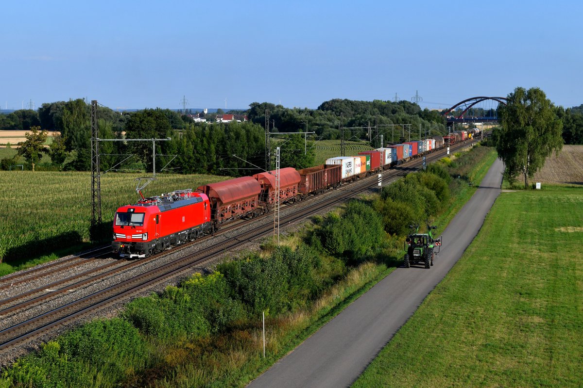 Zum Aufnahmezeitpunkt frisch ausgeliefert war die 193 359 von DB Cargo. Am 26. Juli 2018 hatte sie einen schönen gemischten Güterzug aus München Nord am Haken und lieferte sich im schönsten Abendlicht bei Nordheim ein ungleiches Wettrennen mit einem Traktor.
