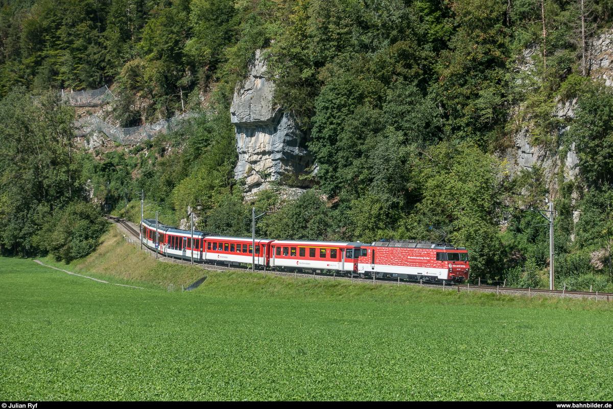 Zusätzlich zu den üblichen ADLER- und FINK-Triebzügen verkehrt auf der Brünigbahn auch im Sommer 2018 zweimal täglich ein Verstärkerzug für Gruppenreisende, welcher aus HGe 4/4 II und Gelenksteuerwagen gebildet wird.<br>
Am 26. August 2018 beförderte die HGe 101 967 den Zug, hier auf der nachmittäglichen Fahrt von Luzern nach Interlaken in der Zahnstangenausfahrt bei Meiringen.