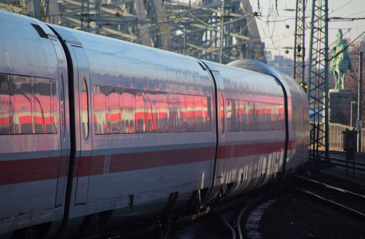 Zwei in einem. Im Tz 161  Bebra , der als ICE 1025 (Hamburg Altona - Frankfurt (Main)Hbf) gleich den Rhein quert, spiegelt sich ein Zug der S-Bahn Köln, aber auch die Reflektion des Lichtes von den Scheiben der S-Bahn ist am Wagen vor dem charakteristischen Speisewagen zu erkennen.

Köln Messe/Deutz, 03. Dezember 2016