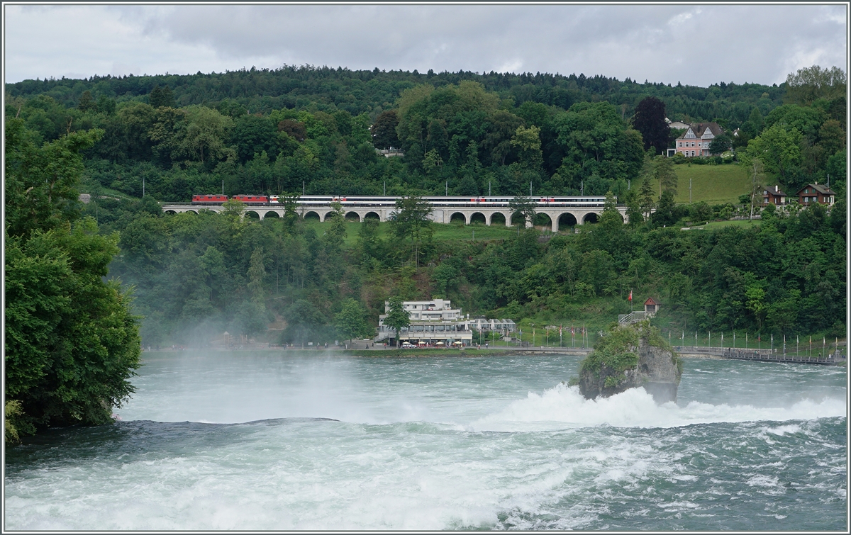 Zwei Re 4/4 II mit dem IC 181 (Stuttgart -Zürich) bei Neuhausen, im Vordergrund stürzt stiebend der Rhein über die Felsen.
Die Aufnahmen entstand in der Nähe des Schloss Laufen am Rheinfall am 18. Juni 2016.
