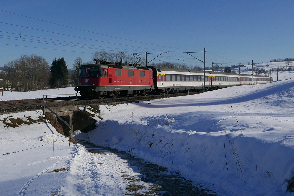 Zwischen Gossau und Flawil befindet sich Re 4/4 II 11300 mit dem IR 2268 von St. Gallen auf der Fahrt nach Basel (29.01.2017).
