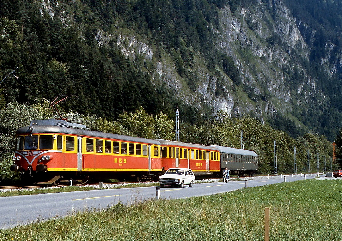 Zwischen St. Anton und Loruns ist der ET 10.103/104 mit einem DB-Kurswagen im August 1982 unterwegs. Beide Fahrzeuge der Montafonerbahn sind umgebaute Dieselfahrzeuge: Der Triebwagen ist ein ex-DR VT 63, während es sich beim Steuerwagen um einen ursprünglich für die schweizer Mittelthurgaubahn gebauten Dieseltriebwagen handelt.