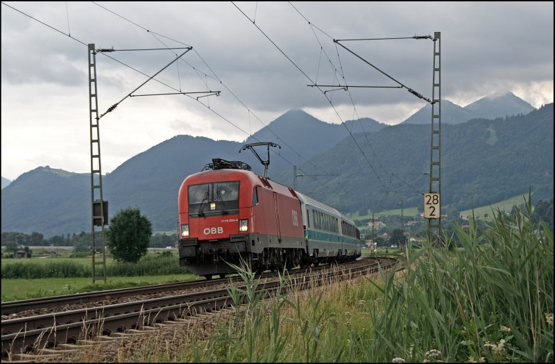 1116 253 legt sich mit dem OEC 112, Klagenfurt - Mnchen Hbf, bei Bernau am Chiemsee in die Kurve. Hinter der Lok laufen die Kurswagen der HZ aus Zagreb mit.
