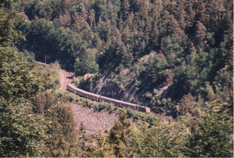 Baureihe 111 zieht hier den IRE bei Streckenkilometer 46,0 hinauf
an die ersten drei kleinen Glastrgertunnels der Niederwasser-Kehre. Diese Aufnahme entstand im Sommer 2006. 