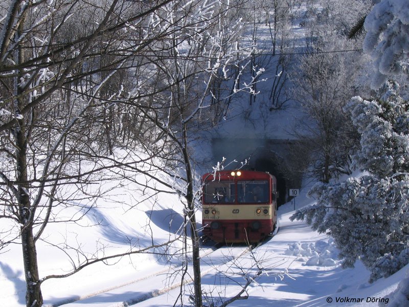 Bei reichlich Neuschnee kommt  Brotbüchse  810 105 als Vlak 26806 Most (Brüx) - Moldava (Moldau im Erzgebirge) aus dem Tunnel bei Mikulov (Niklasberg) gedieselt, 24.02.2006
