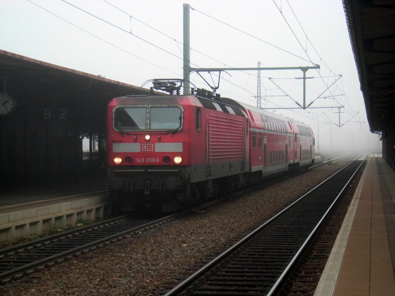 143 058-6 mit RB 17321 bei starkem Nebel im Bahnhof