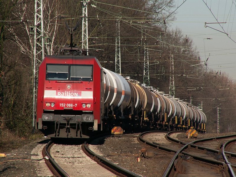 Behangen mit einigen Kesselwagen rauscht diese BR 152 am Bahn�bergang